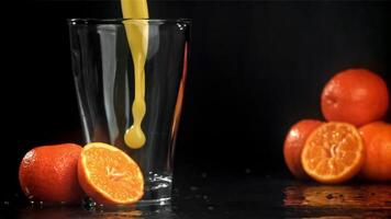 frisch Mandarine Saft ist gegossen in ein Glas. gefilmt auf ein schnelle Geschwindigkeit Kamera beim 1000 fps. hoch Qualität fullhd Aufnahmen video