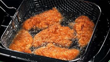 Chicken nuggets are fried in oil. Filmed on a high-speed camera at 1000 fps. High quality FullHD footage video