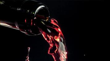 Red wine is poured out of the bottle. Filmed on a high-speed camera at 1000 fps. High quality FullHD footage video