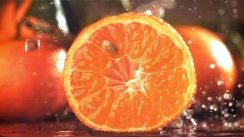 pingos de chuva gotejamento em uma fresco tangerina. filmado em uma alta velocidade Câmera às 1000 fps. Alto qualidade fullhd cenas video