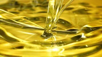 Olive oil with splashes on yellow background. Filmed on a high-speed camera at 1000 fps. High quality FullHD footage video