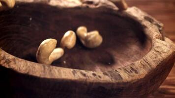 Cashews fall into a wooden bowl. Filmed on a high-speed camera at 1000 fps. High quality FullHD footage video