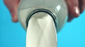 The milk is poured out of the bottle. Filmed on a high-speed camera at 1000 fps. High quality FullHD footage video