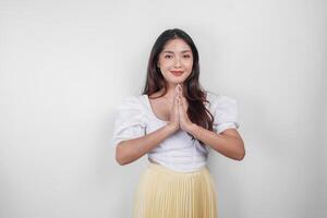 Friendly Asian woman is giving gestures of traditional greetings by her hands photo