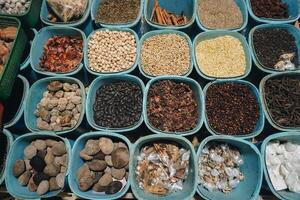 A closeup view of many types of herbs, placed on tray with square and rectangle shape. Traditional Indonesian medicine concept photo