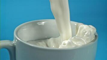 fresco latte è versato in un' tazza. girato su un' alta velocità telecamera a 1000 fps. alto qualità FullHD metraggio video