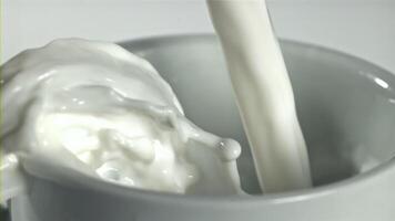 Fresh milk is poured into a cup. Filmed on a high-speed camera at 1000 fps. High quality FullHD footage video