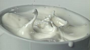 Drops of milk fly into the cup. Filmed on a high-speed camera at 1000 fps. High quality FullHD footage video