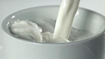 Fresh milk is poured into a cup. Filmed on a high-speed camera at 1000 fps. High quality FullHD footage video