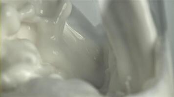 Splashes of milk in a glass. Macro shot. Filmed on a high-speed camera at 1000 fps. High quality FullHD footage video