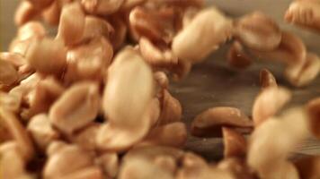 Peanuts fall on the table. Filmed on a high-speed camera at 1000 fps. High quality FullHD footage video