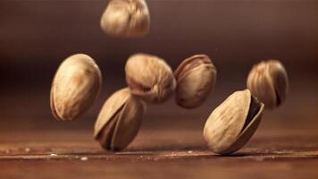 de pistachenoten vallen Aan de tafel. gefilmd Aan een hoge snelheid camera Bij 1000 fps. hoog kwaliteit full HD beeldmateriaal video