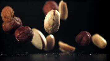 A variety of nuts fall on the table. Filmed on a high-speed camera at 1000 fps. High quality FullHD footage video