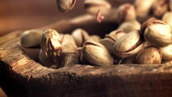 pistachios outono para dentro uma de madeira tigela. filmado em uma alta velocidade Câmera às 1000 fps. Alto qualidade fullhd cenas video