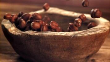 Hazelnuts fall into a wooden bowl. Filmed on a high-speed camera at 1000 fps. High quality FullHD footage video