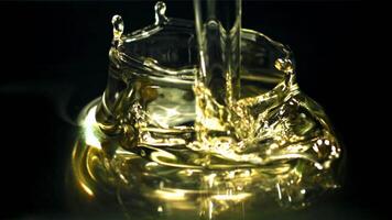 Olive oil with splashes on black background. Filmed on a high-speed camera at 1000 fps. High quality FullHD footage video