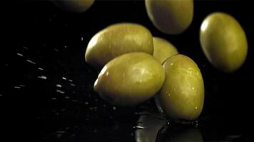 Fresh olives fall with splashes into the oil. Filmed on a high-speed camera at 1000 fps. High quality FullHD footage video