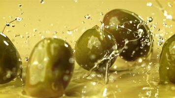 frisch Oliven fallen mit spritzt in das Öl. gefilmt auf ein schnelle Geschwindigkeit Kamera beim 1000 fps. hoch Qualität fullhd Aufnahmen video