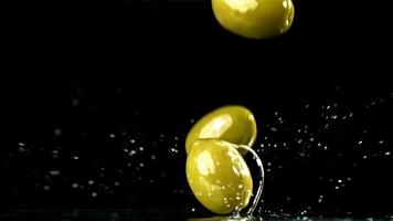 Fresh olives fall with splashes into the oil. Filmed on a high-speed camera at 1000 fps. High quality FullHD footage video