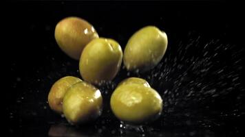 Fresh olives fall with splashes into the oil. Filmed on a high-speed camera at 1000 fps. High quality FullHD footage video