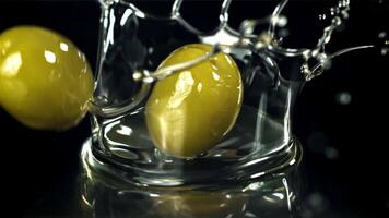 Fresh olives fall with splashes into the oil. Filmed on a high-speed camera at 1000 fps. High quality FullHD footage video