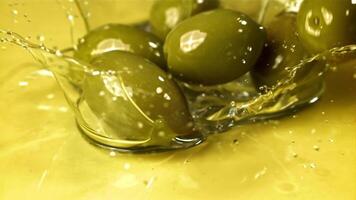 Fresh olives fall with splashes into the oil. Filmed on a high-speed camera at 1000 fps. High quality FullHD footage video