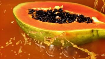 The papaya falls into the juice with splashes. Filmed on a high-speed camera at 1000 fps. High quality FullHD footage video