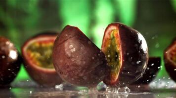 Fresh tropical passion fruit falls on a wet table. Filmed on a high-speed camera at 1000 fps. High quality FullHD footage video