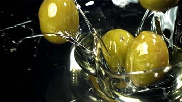 Fresh olives fall with splashes into the oil. Filmed on a high-speed camera at 1000 fps. High quality FullHD footage video