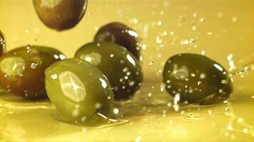 Fresh olives fall with splashes into the oil. Filmed on a high-speed camera at 1000 fps. High quality FullHD footage video