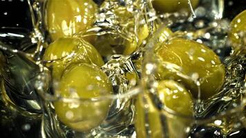 Fresh olives fall with splashes into the oil. Filmed on a high-speed camera at 1000 fps. High quality FullHD footage video