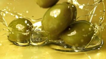 frisch Oliven fallen mit spritzt in das Öl. gefilmt auf ein schnelle Geschwindigkeit Kamera beim 1000 fps. hoch Qualität fullhd Aufnahmen video
