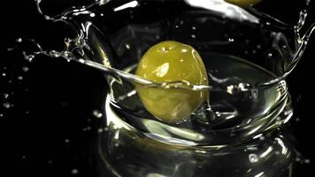 Fresh olives fall with splashes into the oil. Filmed on a high-speed camera at 1000 fps. High quality FullHD footage video