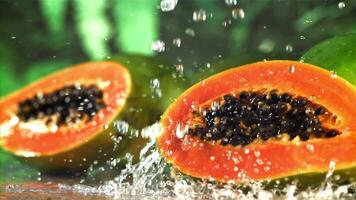 frisch tropisch Papaya mit Tropfen und spritzt von Wasser. gefilmt auf ein schnelle Geschwindigkeit Kamera beim 1000 fps. hoch Qualität fullhd Aufnahmen video