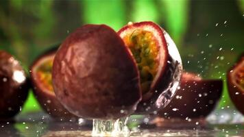 frisch tropisch Leidenschaft Obst Stürze auf ein nass Tisch. gefilmt auf ein schnelle Geschwindigkeit Kamera beim 1000 fps. hoch Qualität fullhd Aufnahmen video