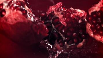 Part of the pomegranate falls into the juice with splashes. Filmed on a high-speed camera at 1000 fps. High quality FullHD footage video