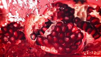 Splashed water pours onto fresh pomegranates. Filmed on a high-speed camera at 1000 fps. High quality FullHD footage video