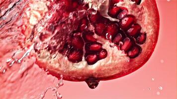 Splashed water pours onto fresh pomegranates. Filmed on a high-speed camera at 1000 fps. High quality FullHD footage video