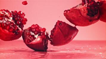 Chunks of fresh pomegranate fall on the table. Filmed on a high-speed camera at 1000 fps. High quality FullHD footage video