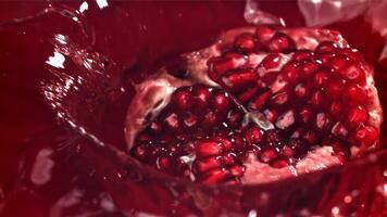 Part of the pomegranate falls into the juice with splashes. Filmed on a high-speed camera at 1000 fps. High quality FullHD footage video