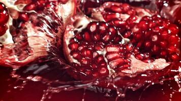 Part of the pomegranate falls into the juice with splashes. Filmed on a high-speed camera at 1000 fps. High quality FullHD footage video