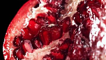 Splashed water pours onto fresh pomegranates. Filmed on a high-speed camera at 1000 fps. High quality FullHD footage video