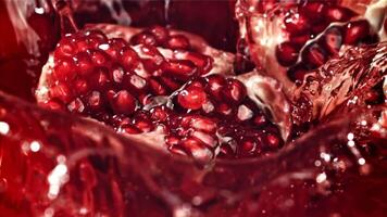 Part of the pomegranate falls into the juice with splashes. Filmed on a high-speed camera at 1000 fps. High quality FullHD footage video