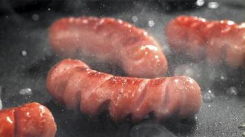 Sausages are fried with splashes in a pan. Filmed on a high-speed camera at 1000 fps. High quality FullHD footage video
