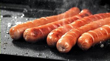 Sausages are fried with splashes in a pan. Filmed on a high-speed camera at 1000 fps. High quality FullHD footage video