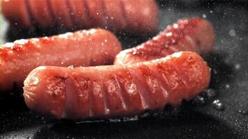 Sausages are fried with splashes in a pan. Filmed on a high-speed camera at 1000 fps. High quality FullHD footage video