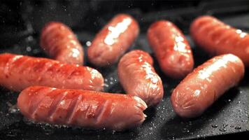 Sausages are fried with splashes in a pan. Filmed on a high-speed camera at 1000 fps. High quality FullHD footage video