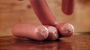 Sausages fall on a wooden table. Filmed on a high-speed camera at 1000 fps. High quality FullHD footage video