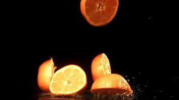skivor av färsk mandariner faller på svart bakgrund. filmad på en hög hastighet kamera på 1000 fps. hög kvalitet full HD antal fot video