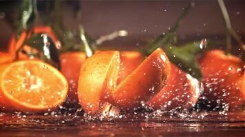 A tangerine breaks into two halves when it falls. Filmed on a high-speed camera at 1000 fps. High quality FullHD footage video